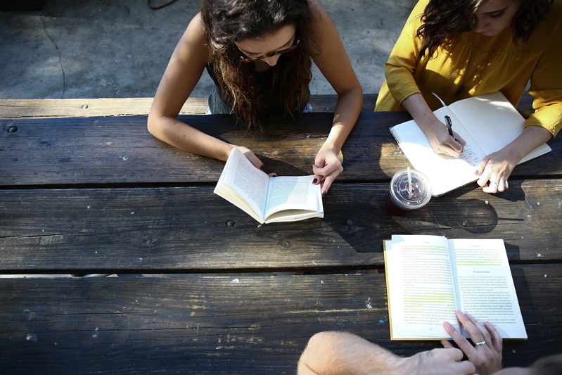 three people studying at table